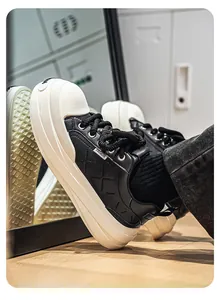 Close-up of black leather platform sneaker with quilted detail and chunky white sole for men.