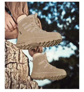 Detail shot of tan tactical outdoor boots with thick lug soles on rocky terrain