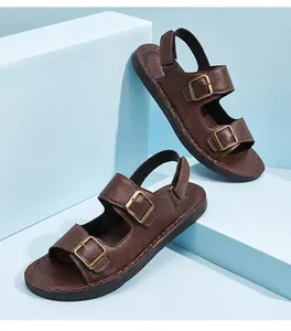 Vista detallada de sandalias de cuero marrón para hombre con hebillas metálicas dobles.