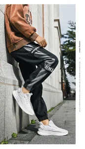 Λευκά ανδρικά αναπνεύσιμα sneakers fly-knit σε σκηνικό street style εξωτερικού χώρου.