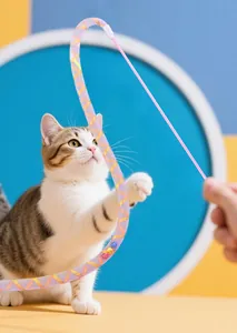 Detail view of a colorful sequined ribbon cat teaser wand being used to play with a cat