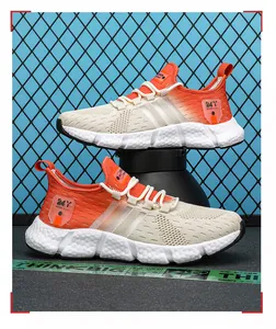 Close-up view of stylish orange gradient fly-knit sneakers with chunky white popcorn soles.