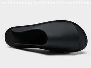 Vue de dessus de claquettes minimalistes noires pour hommes avec bords cousus