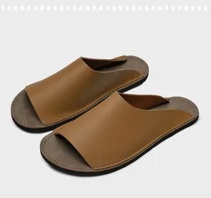 Vue détaillée de mules minimalistes en cuir marron pour hommes avec semelle en caoutchouc cousue.