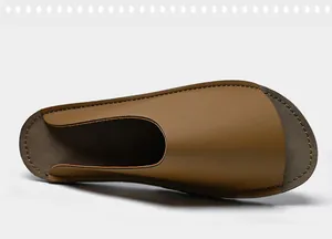Détail de dessus d'un chausson en cuir marron montrant texture lisse et couture