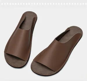 Vue détaillée montrant le design minimaliste des claquettes en cuir marron pour hommes