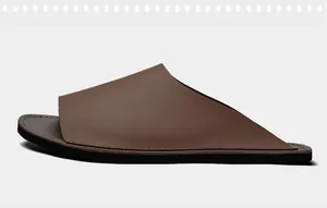 Vue de profil de claquettes de plage minimalistes en cuir marron pour hommes avec semelle noire