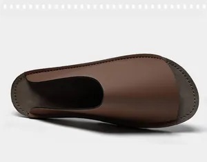 Vue de dessus montrant la texture du cuir marron lisse et les coutures de la mule homme.
