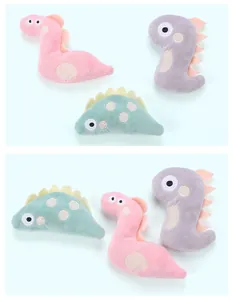Set di peluche a forma di dinosauro per gatti con erba gatta in colori pastello.