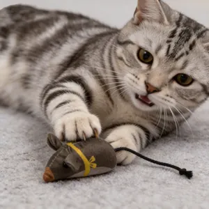 Gatto soriano che gioca con un giocattolo a forma di topo in peluche su un tappeto