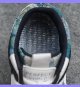 Detailopname van ademende mesh voering en Perfect World tonglabel op retro sneaker