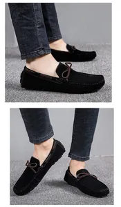 Detailansicht von schwarzen Wildleder-Loafern mit brauner Schleife und Denim-Jeans.