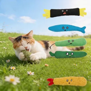 Close-up of various colorful plush catnip toys with a cat playing on green grass.