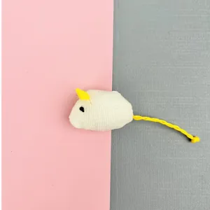 Close-up detail of small white canvas catnip mouse toy with yellow felt ears and tail