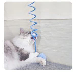 Interaktives blaues Spiralfeder-Katzenspielzeug mit Plüschball, von flauschiger Katze gebissen