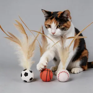 Close-up of three sports-themed feather ball toys for cats with calico cat playing