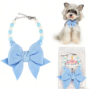 Detailed view of large blue bow pet collar with pearl beads and retail unicorn packaging