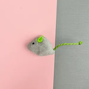 Close-up of small grey plush mouse cat toy with green ears and twisted tail