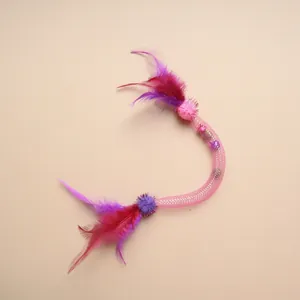 Détail d'un jouet pour chat en tube maillé flexible rose avec plumes et clochettes