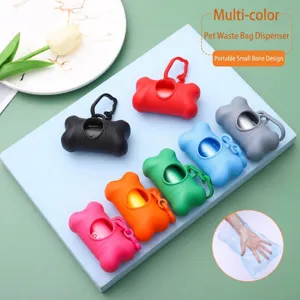 Detail view of various colorful bone-shaped pet waste bag dispensers on a blue platform