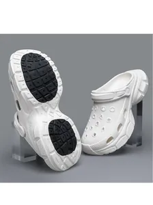 Detail showing the anti-slip black sole and side profile of white platform clogs