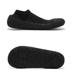 Detaillierte Seiten- und Sohlenansicht schwarzer Yoga-Schuhe mit körniger rutschfester Außensohle.