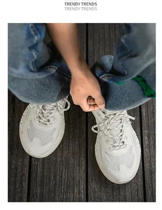 Vista superior de zapatillas chunky de malla blanca para hombre sobre fondo de madera.