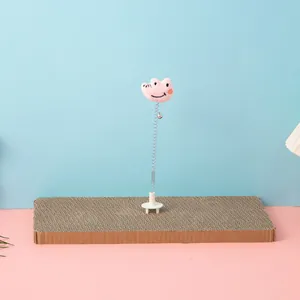 Macro view of the cat scratching board featuring a pink plush spring toy for pet play.