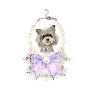 Detailed view of an elegant pet pearl necklace with a large purple bow and rhinestones