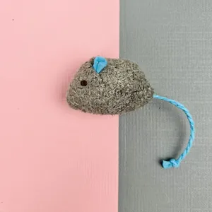 Detailed shot showing the texture of a gray plush catnip mouse toy with blue braided tail.