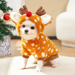 Detailed shot of a cute white dog wearing a plush orange reindeer outfit for Christmas.