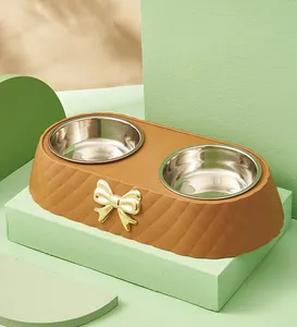 Detail of a luxury brown double pet bowl featuring a gold bow and quilted base