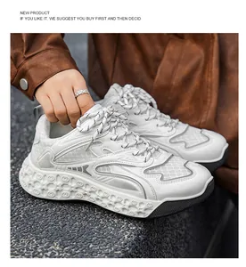 Primer plano de zapatillas chunky blancas de malla para hombre con suela texturizada.
