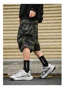Vista detallada de zapatillas de malla plateada para hombre con pantalones camuflados