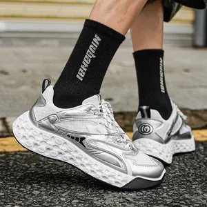 Zapatillas chunky dad de malla plateada para hombre en pavimento urbano moderno.