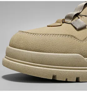 Nahaufnahme eines khakifarbenen Wildledersneakers mit dicker Plateausohle und Nähten