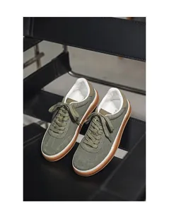 Close-up detail of stylish olive green suede sneakers featuring durable gum rubber soles