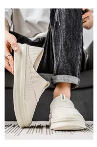 Vista detallada de los mocasines de lona beige transpirables para hombre con suelas gruesas