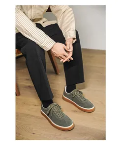Olive green suede sneakers for men shown on model in a stylish lifestyle setting