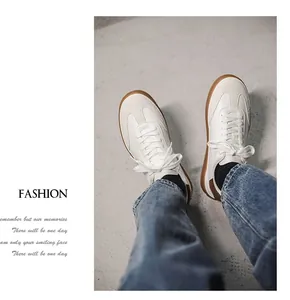 Detailed view of stylish white suede panel sneakers with classic gum sole for men.