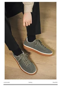 Close-up detail of men's fashionable green suede casual sneakers worn with black trousers