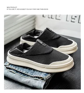 Detalle de zuecos de lona negra transpirables para hombre con suelas blancas gruesas.