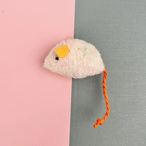 Detail showing the plush texture and orange braided tail of a catnip mouse toy.
