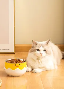Cute yellow duck pet feeding bowl with stainless steel insert and cat sitting nearby