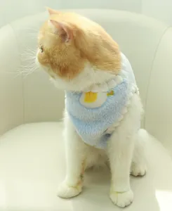 Close-up detail of a soft light blue plush pet vest with cute yellow egg pattern