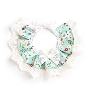 Primer plano de un babero floral para mascotas con encaje blanco y lazo decorativo.