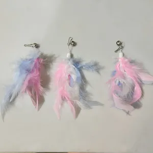 A detailed view showing three colorful feather cat wand replacement heads with small silver bells