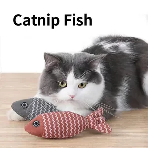 Nahaufnahme einer Katze, die mit zwei Zickzack-Katzenminzen-Fischspielzeugen spielt.