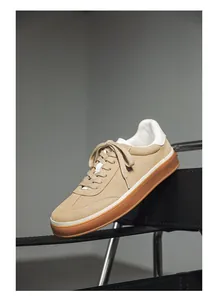 Detailed macro view of tan suede minimalist sneakers with premium gum rubber outsole.