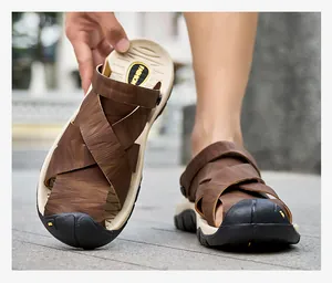 Detailweergave van de bruine herensandalen van echt leer voor buiten en op het strand.